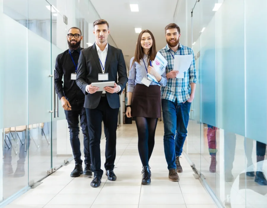 group of young attractive professionals walking down bright hallway